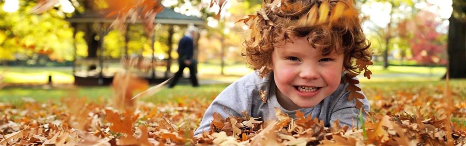 City Park kid in autumn leaves