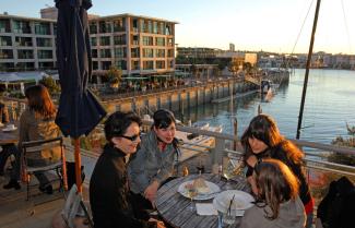 Couple sitting in Auckland Viaduct enjoying lunch.